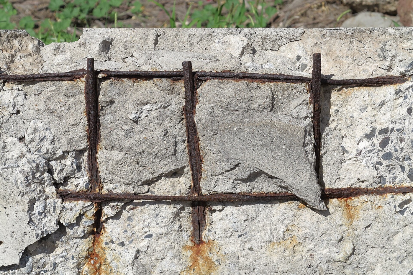 Corroded steel bars exposed in a concrete wall where the cover has broken away after carbonation.