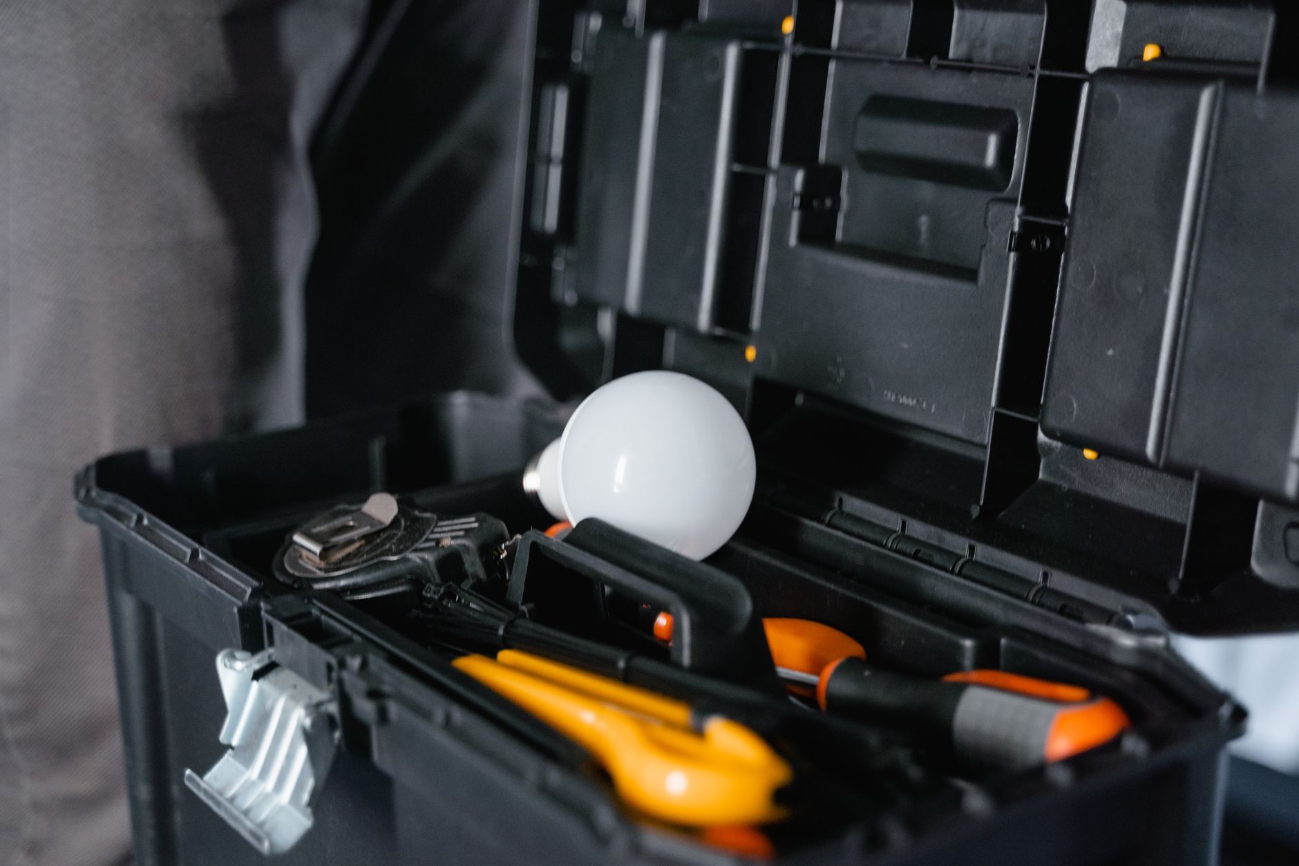 Handyman toolbox with tools and a spare light bulb